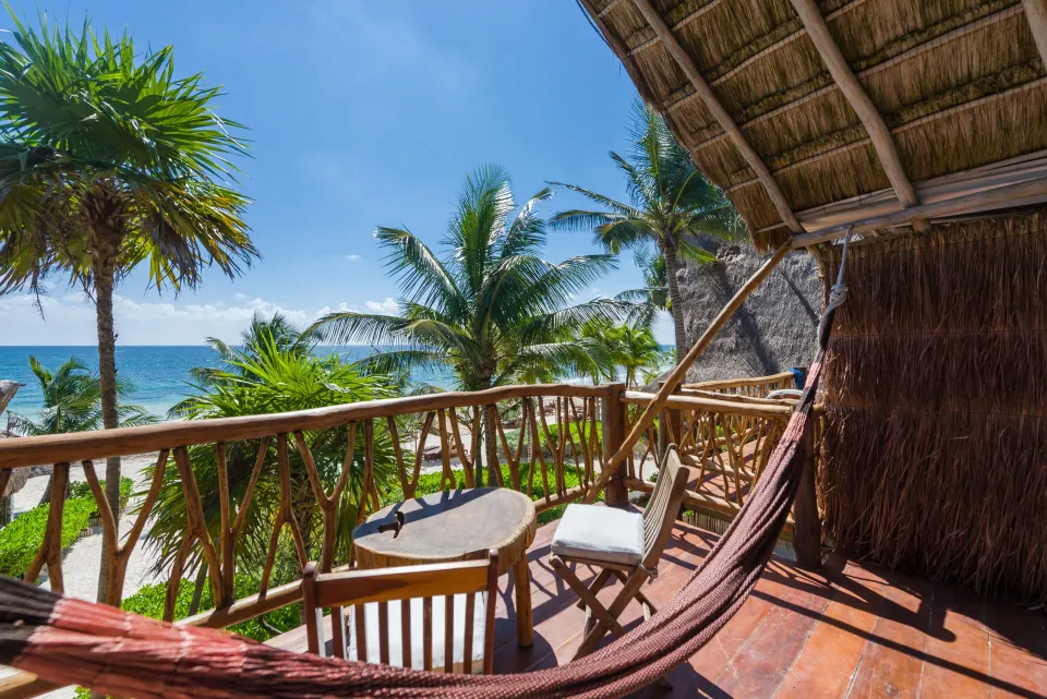 Shaded balcony with hammock, chairs and ocean view from a Junior Suite at Ahau Tulum