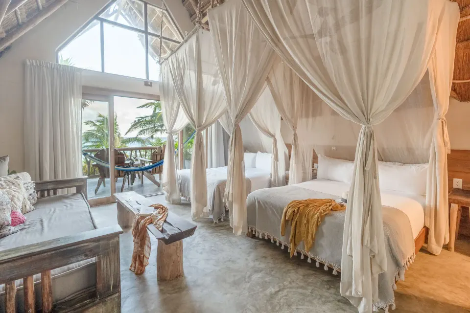 Full view of the Junior Suite Oceanfront Top Level showing beds and balcony at Ahau Tulum