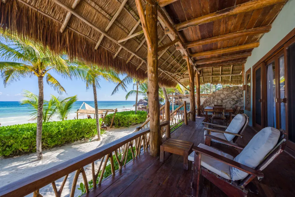 Long covered wooden veranda of the Master Suite Oceanfront Beach Level looking toward the beach at Ahau Tulum