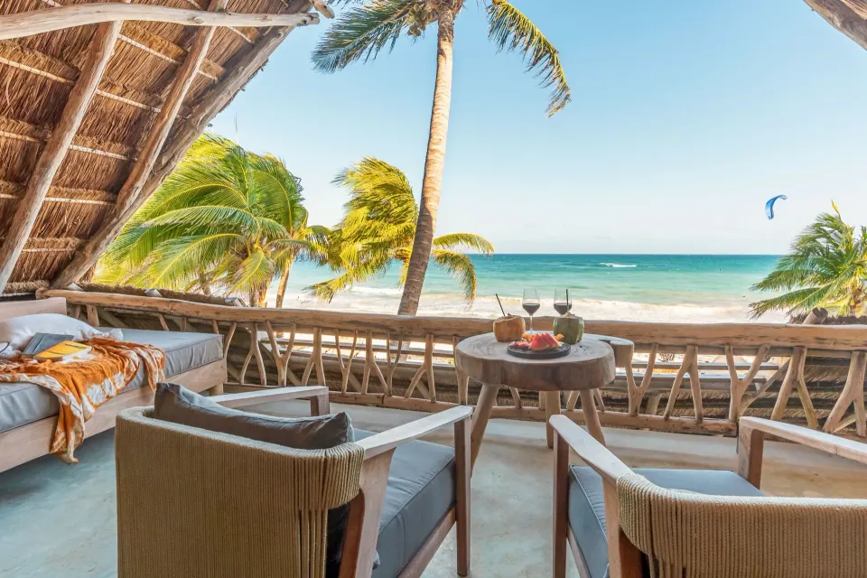 Oceanfront master suite balcony with seating and sea view at Ahau Tulum