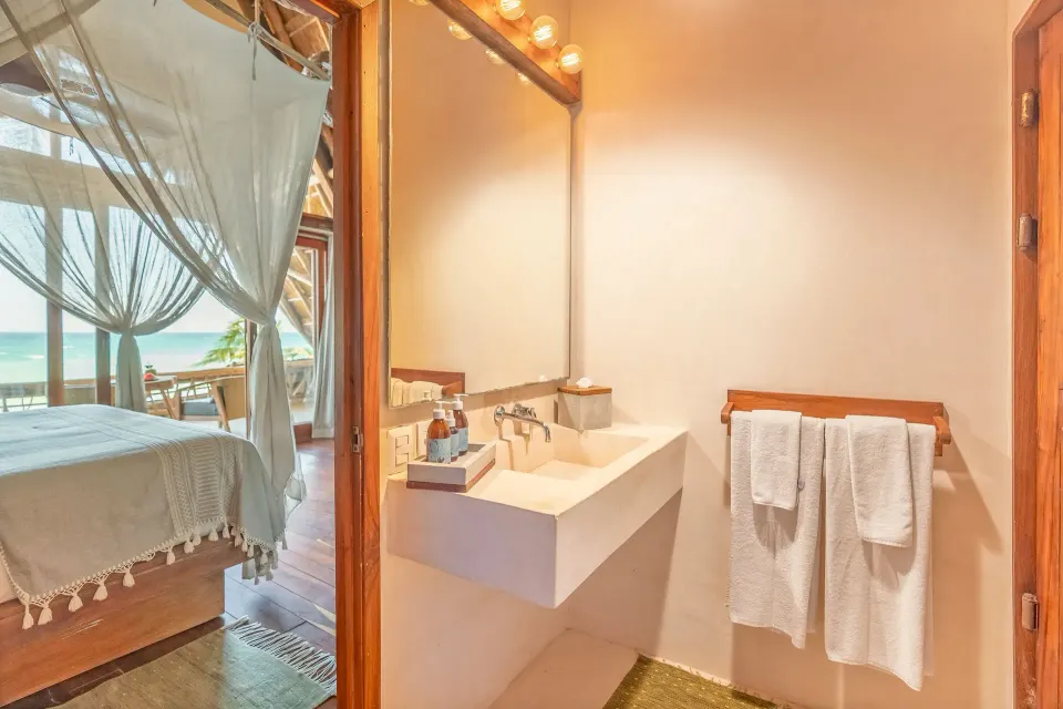 Bathroom sink and mirror opening to the Master Suite and balcony at Ahau Tulum