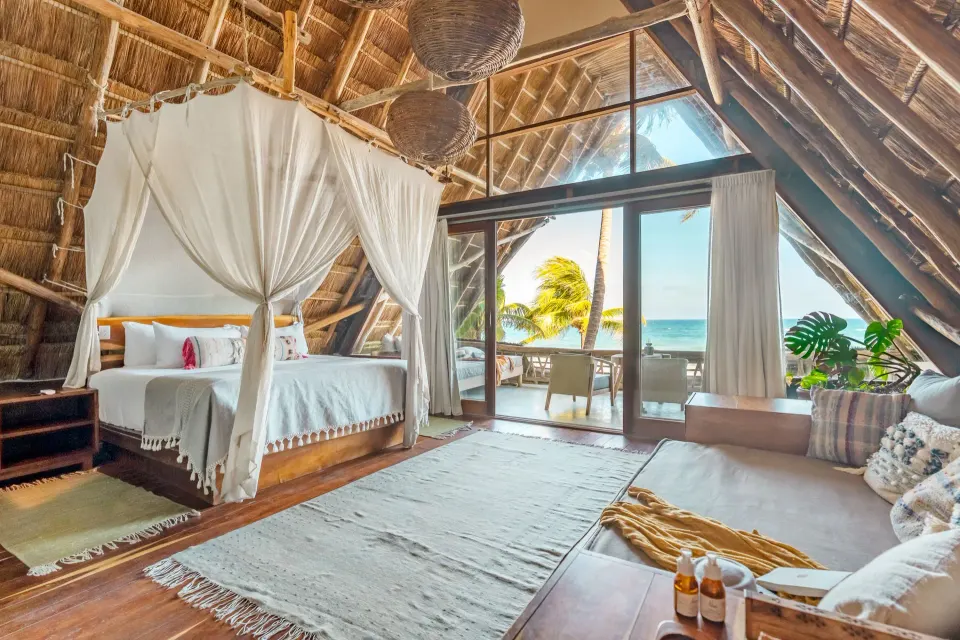 Interior of Master Suite Oceanfront showing four-poster bed and balcony at Ahau Tulum