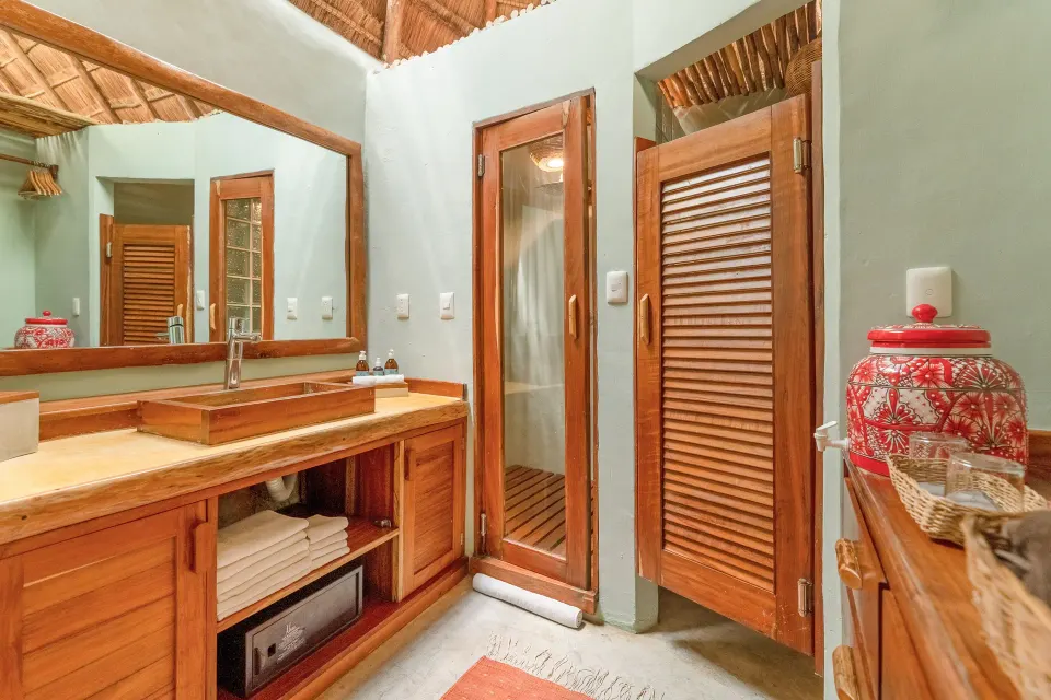 Bathroom vanity and wooden doors in a Signature Room at Ahau Tulum