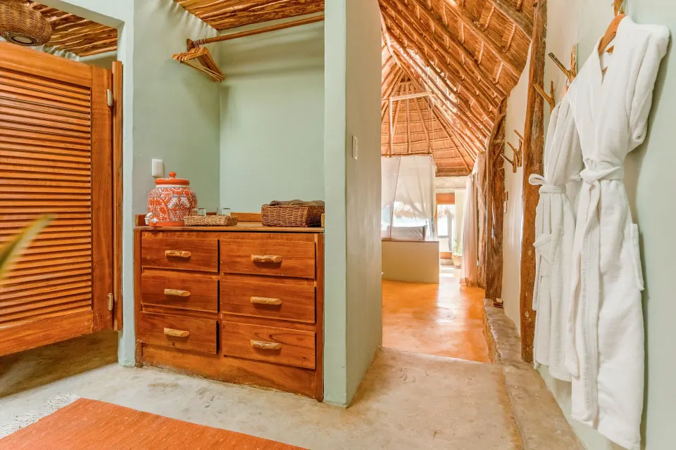 Hallway with drawers and robes leading to the bedroom in a Signature Room at Ahau Tulum