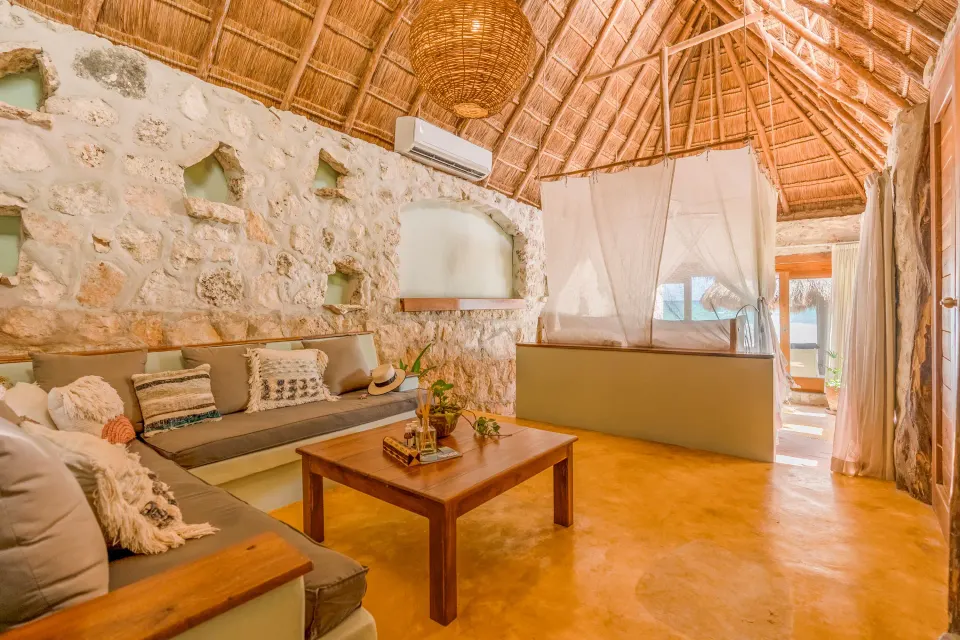 Sitting area and canopy bed seen from the lounge in a Signature Room at Ahau Tulum