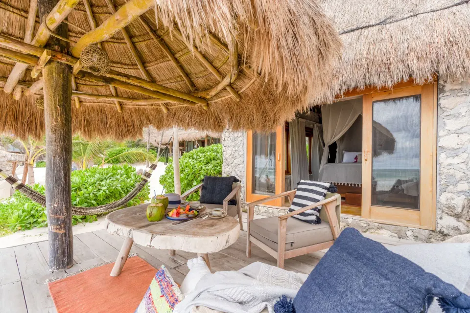 Thatched palapa seating area just outside a Signature Room at Ahau Tulum