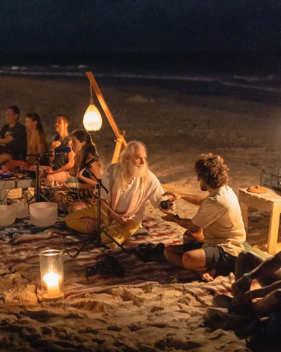 Beach sound-healing circle by candlelight at night at Ahau Tulum