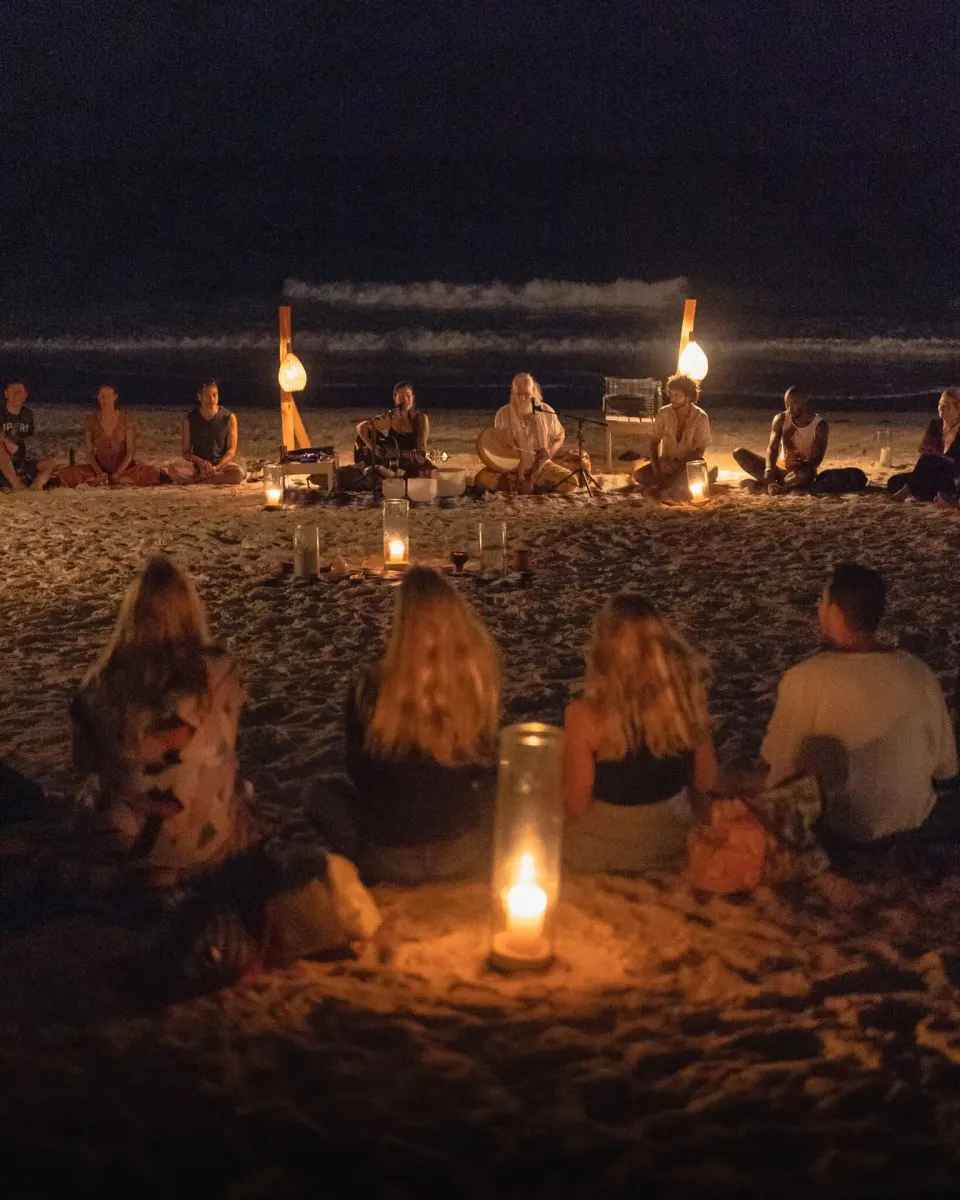 Audience watching a candlelit beachfront ceremony at Ahau Tulum after dark