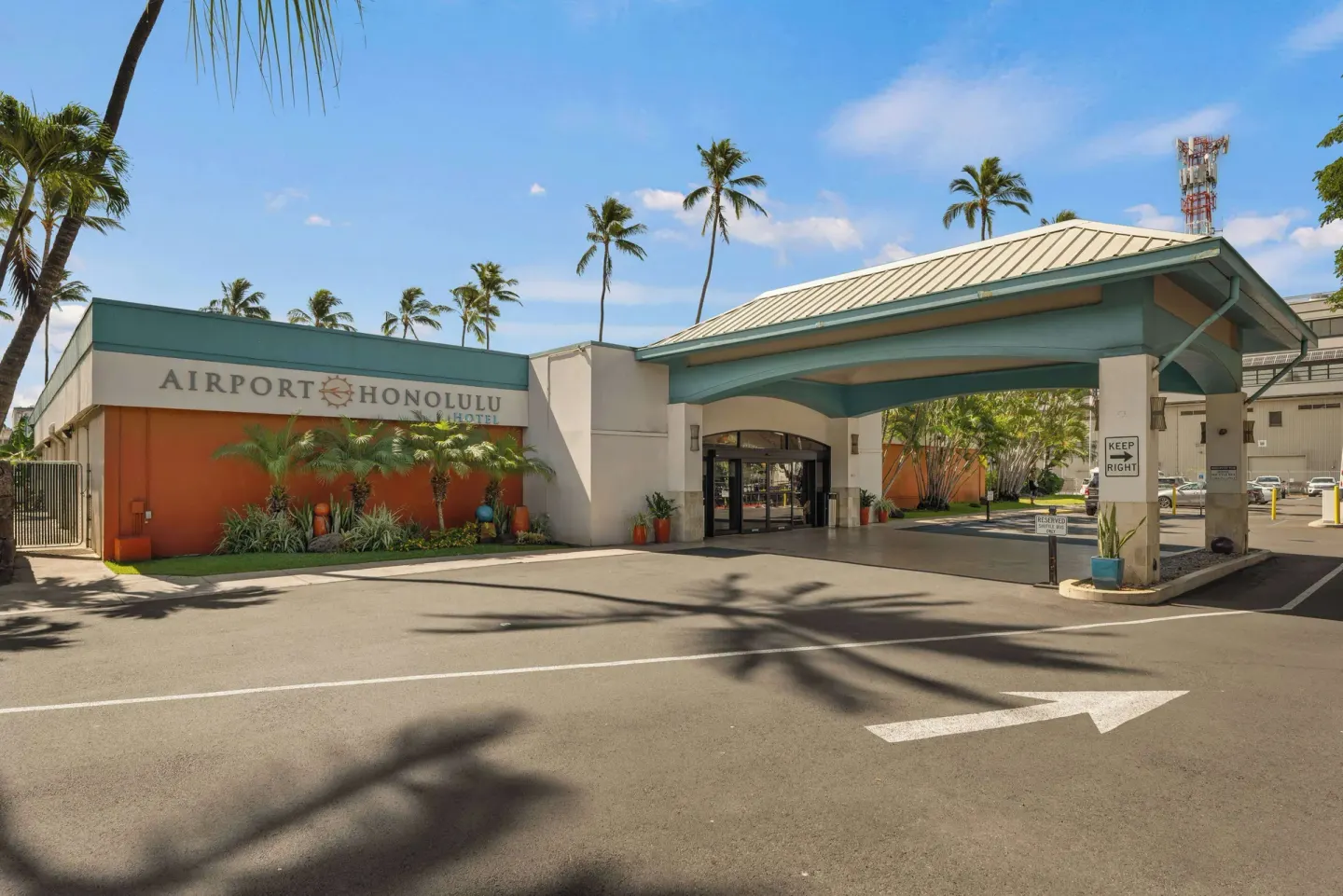 Daytime hotel entrance and covered driveway at Airport Honolulu Hotel.
