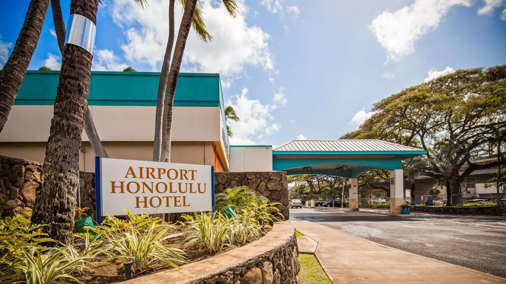 Entrance sign and covered driveway at Airport Honolulu Hotel.