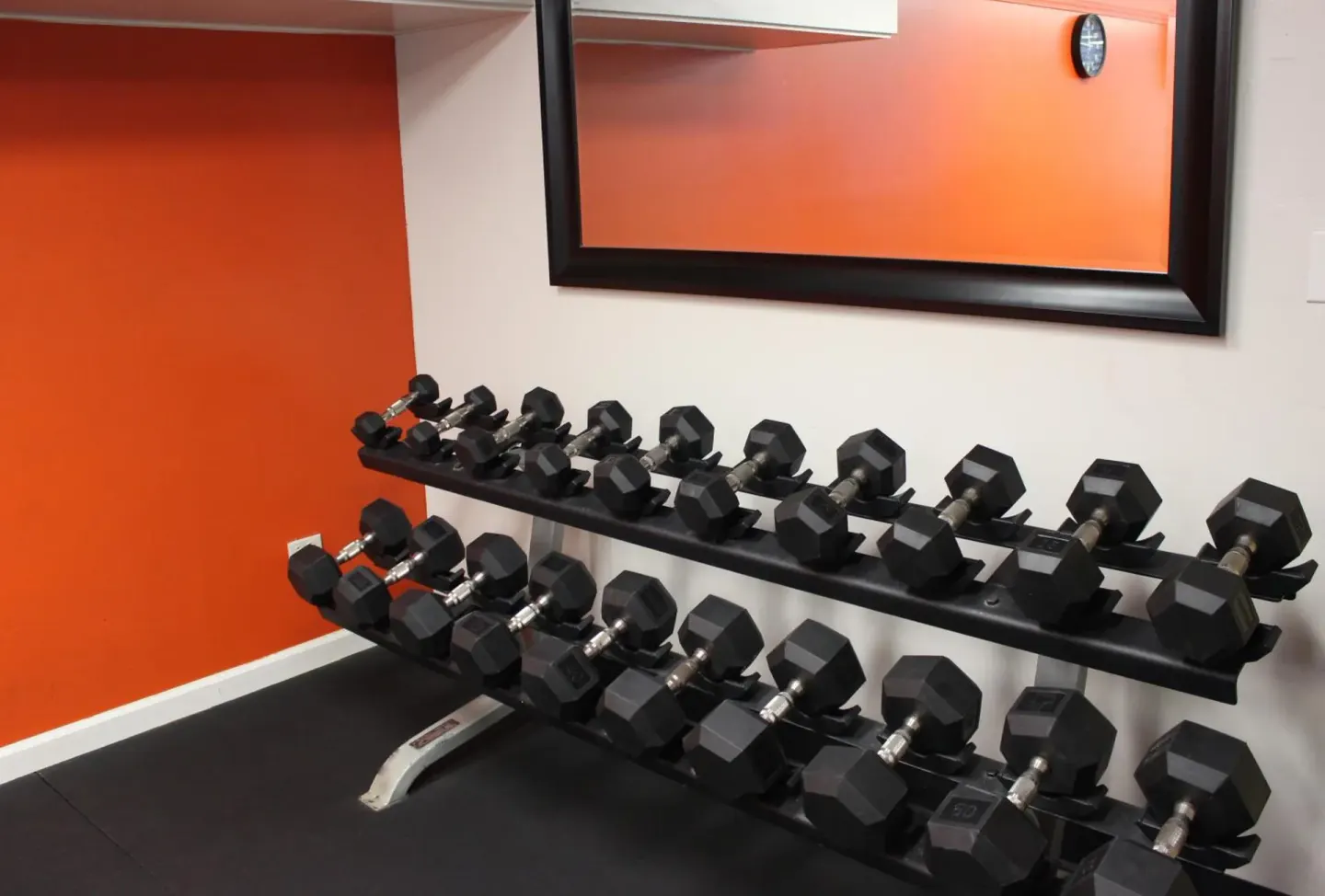 Fitness room dumbbell rack and mirror at Airport Honolulu Hotel.