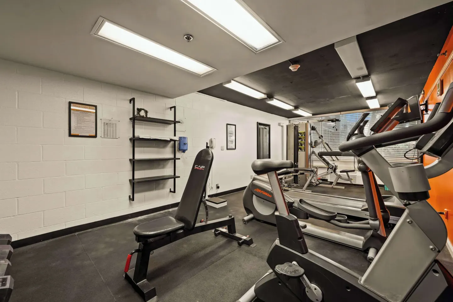 Fitness room with bench, treadmill, elliptical and weight station at Airport Honolulu Hotel.