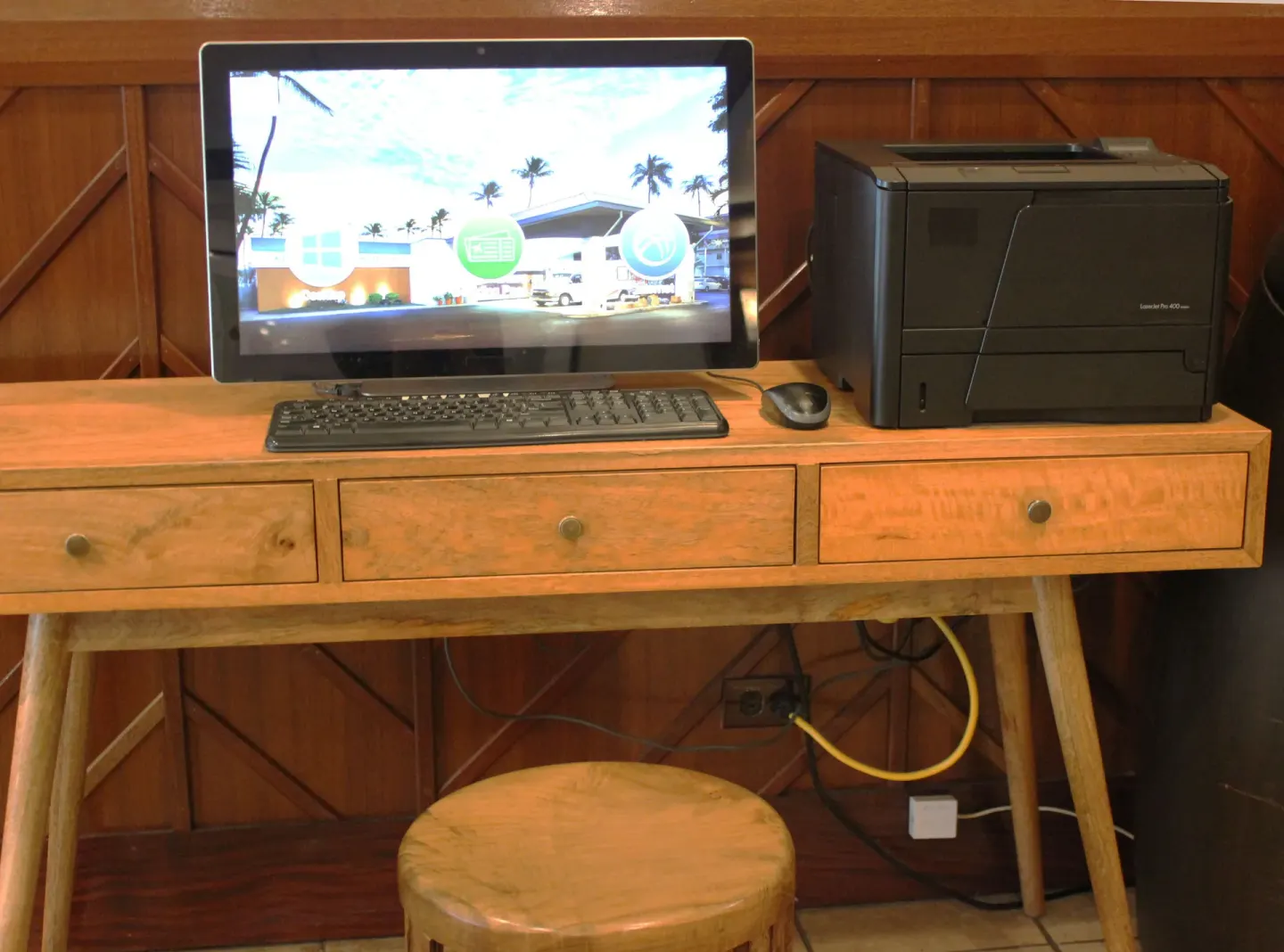 Guest computer workstation and printer on a wooden desk at Airport Honolulu Hotel.
