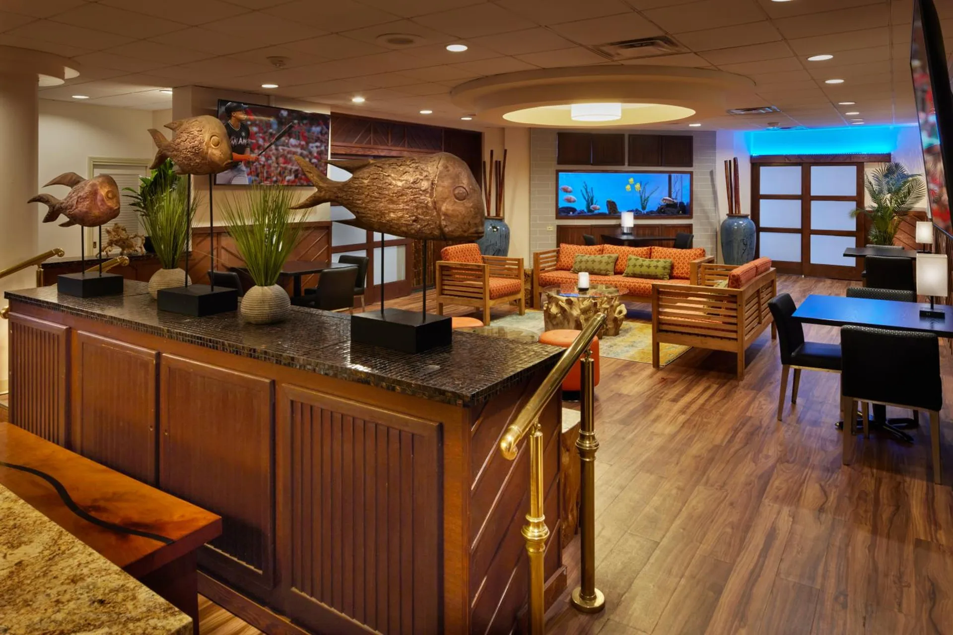 Lobby lounge with fish sculptures and wood seating at Airport Honolulu Hotel.