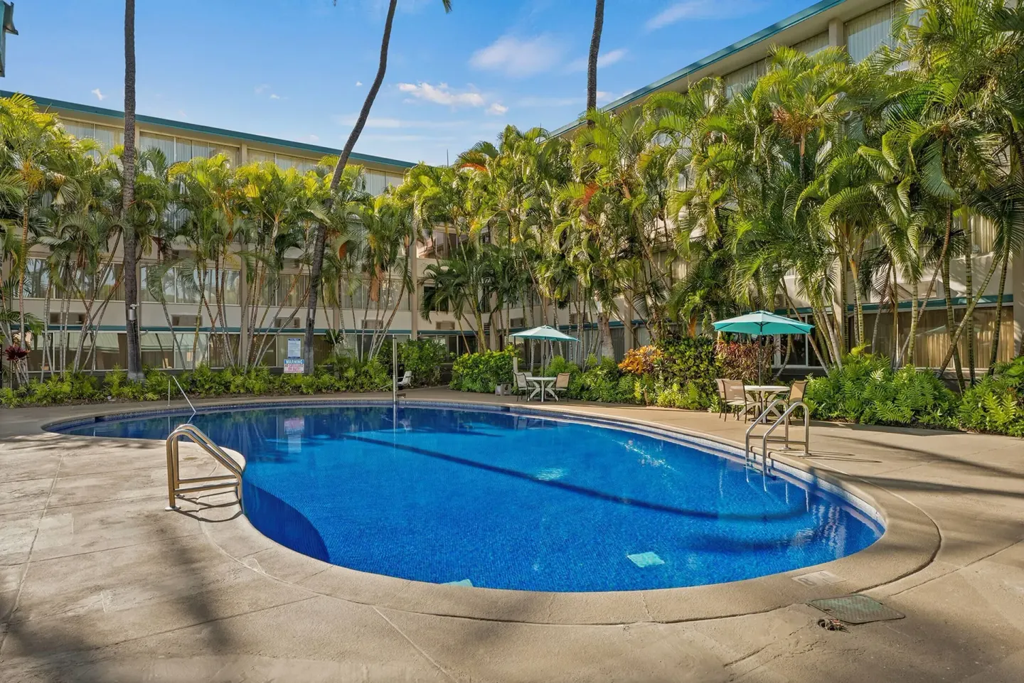 Swimming pool enclosed by tropical landscaping at Airport Honolulu Hotel.