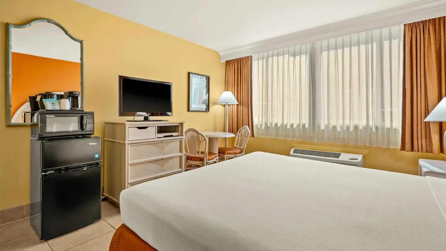 Non-smoking room with bed, TV, mini-fridge and window at Airport Honolulu Hotel.
