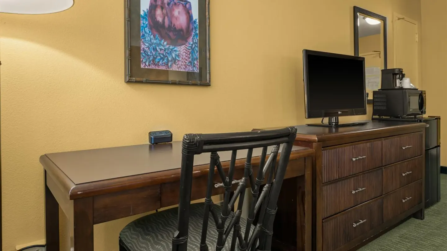 Non-smoking room desk with chair, TV dresser and appliances at Airport Honolulu Hotel.