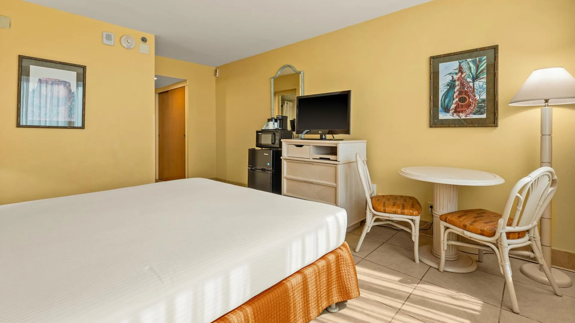 Non-smoking room with bed, TV, dining table and chairs at Airport Honolulu Hotel.