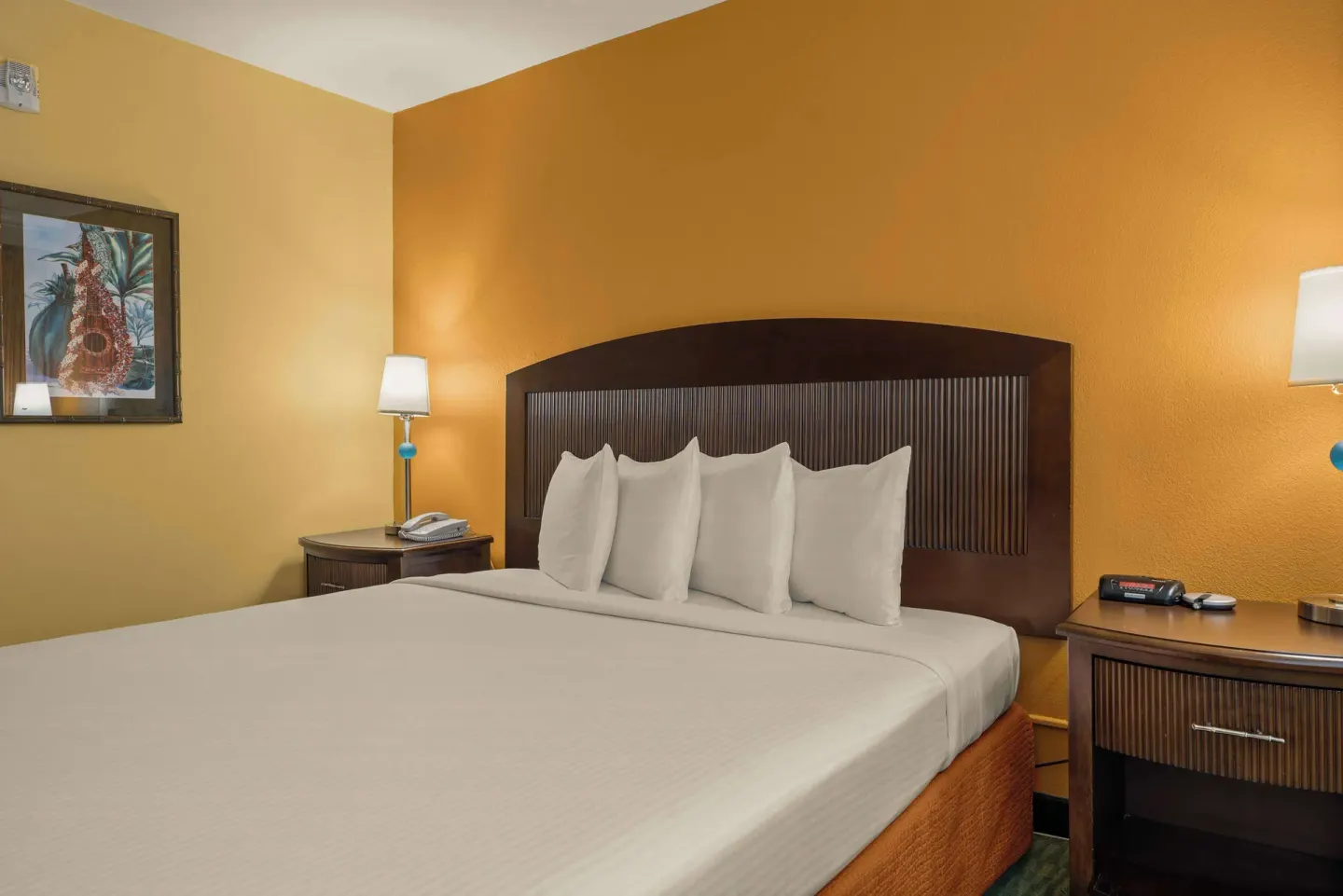 Close view of the king bed, headboard, lamps, and nightstands at Airport Honolulu Hotel.