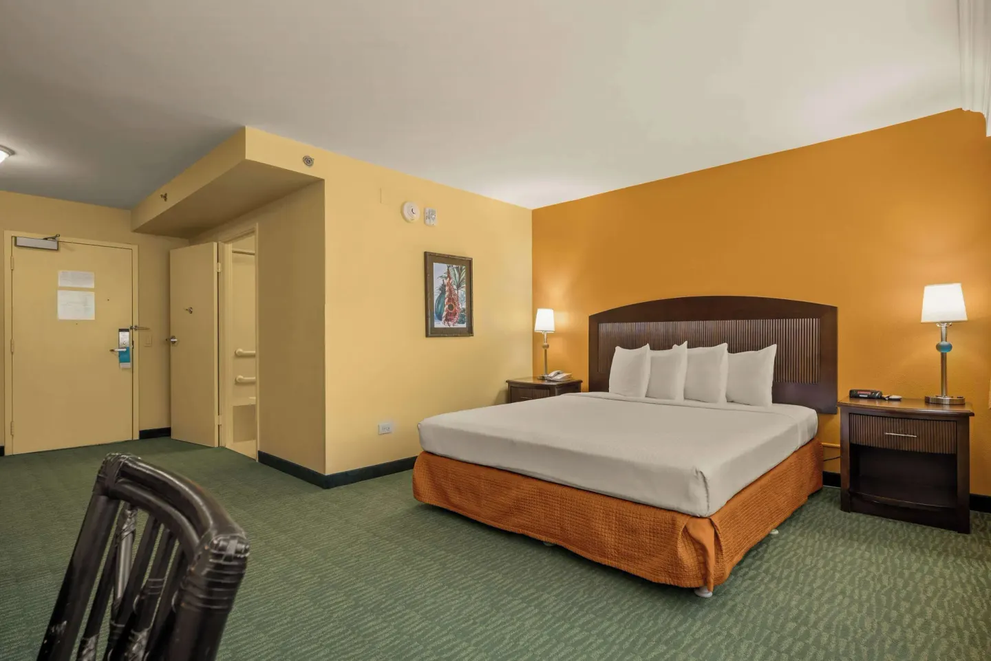 Non-smoking king guest room with entry door and bed at Airport Honolulu Hotel.
