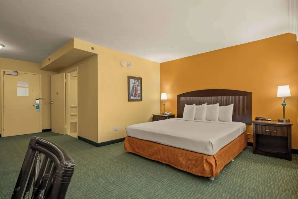 Non-smoking king guest room with entry door and bed at Airport Honolulu Hotel.