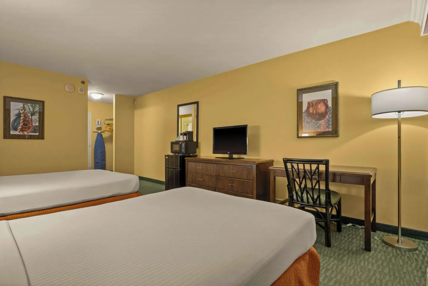 Non-smoking two-bed room with TV dresser, desk, chair, and floor lamp at Airport Honolulu Hotel.
