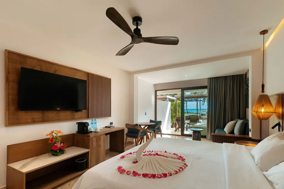 King bed and TV with terrace view at Akumal Bay Beach & Wellness Resort