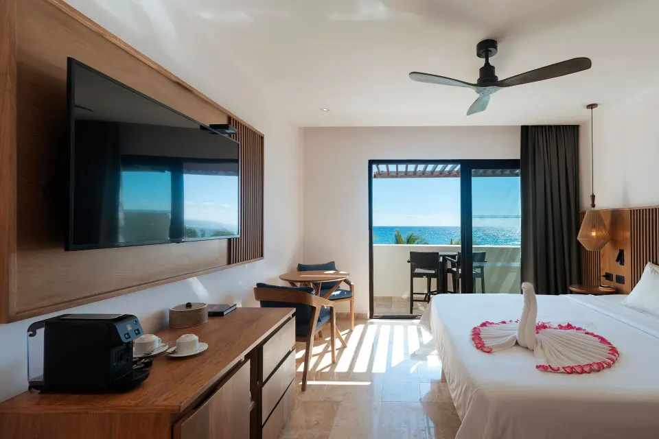 Bright junior suite with king bed and seaside balcony at Akumal Bay Beach & Wellness Resort
