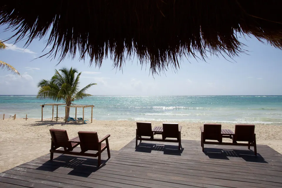 Wooden deck with lounge chairs facing the ocean at Akumal Bay Beach & Wellness Resort