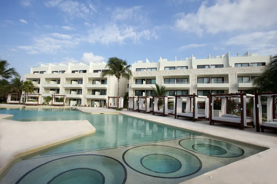 Resort pool with circular shallow seats and cabanas at Akumal Bay Beach & Wellness Resort