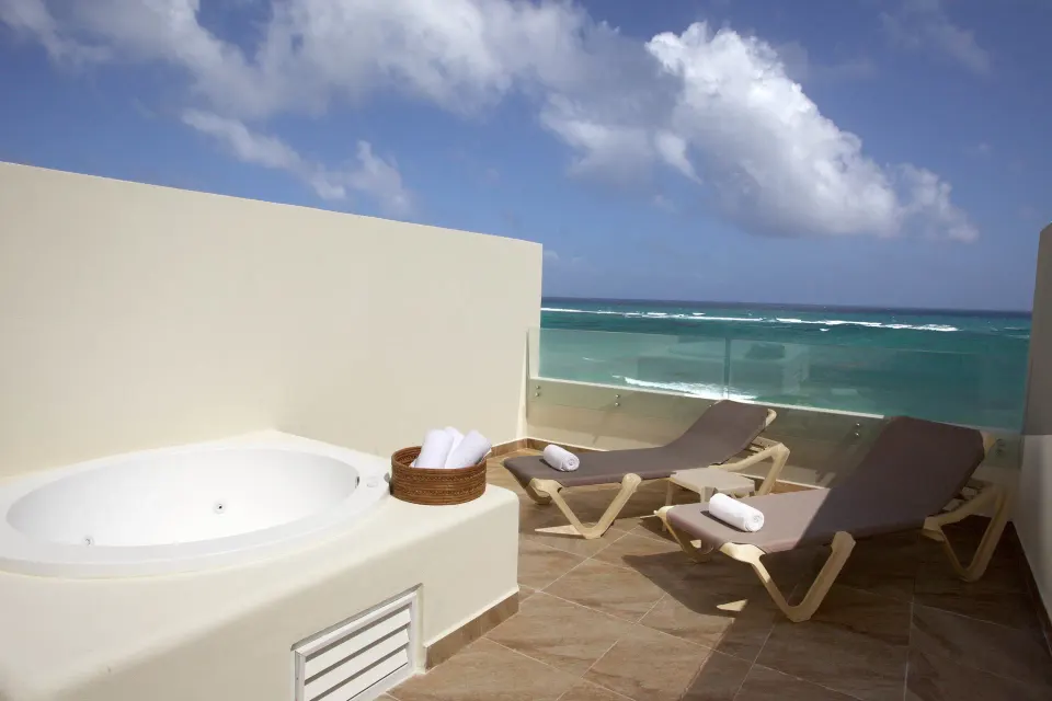 Rooftop terrace with jacuzzi and loungers facing the ocean at Akumal Bay Beach & Wellness Resort