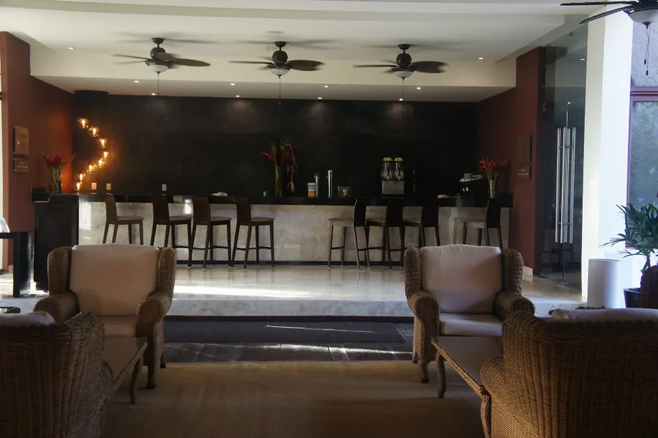 Indoor bar with high stools and lounge seating at Akumal Bay Beach & Wellness Resort