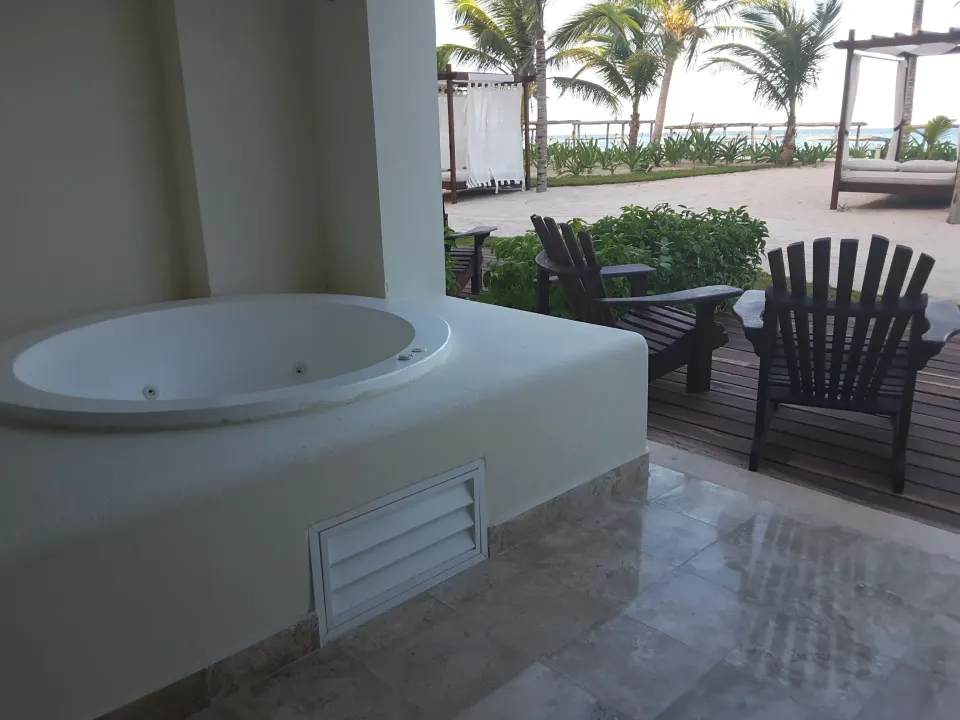 Outdoor wood deck with chairs and a private whirlpool tub at Akumal Bay Beach & Wellness Resort