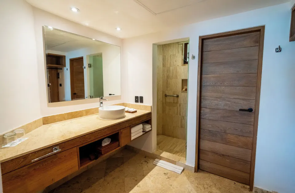 Bathroom vanity and entrance to shower in Junior Suite at Akumal Bay Beach & Wellness Resort
