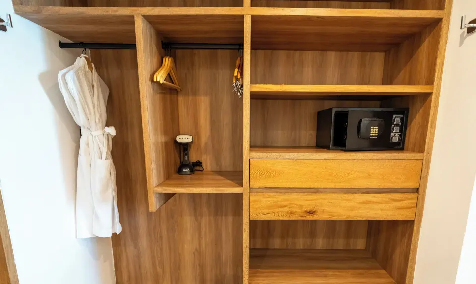 Open closet with safe, robe and hangers in Junior Suite at Akumal Bay Beach & Wellness Resort