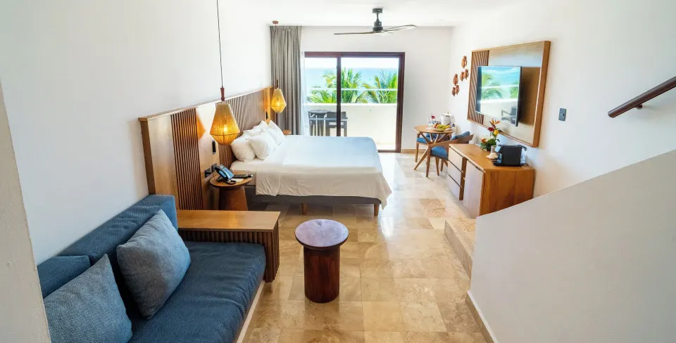 Junior Suite Penthouse open-plan bedroom and seating area at Akumal Bay Beach & Wellness Resort