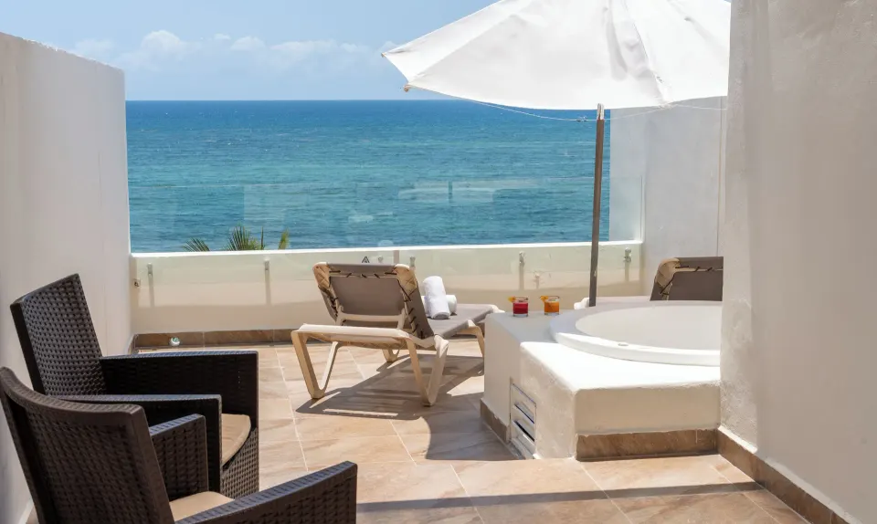 Rooftop terrace with loungers, hot tub and ocean view at Akumal Bay Beach & Wellness Resort