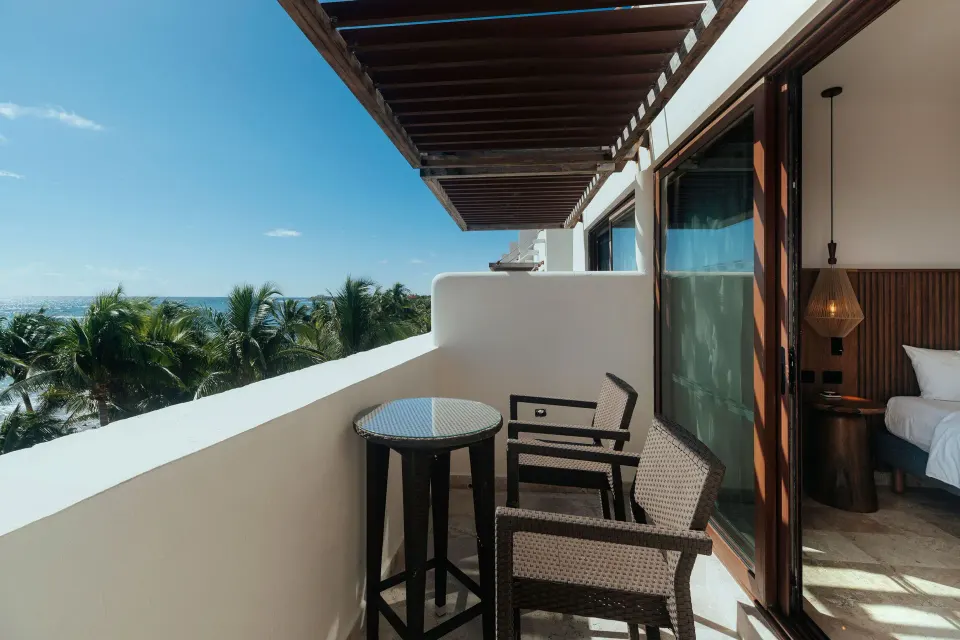 Balcony seating with ocean and palms seen from Junior Suite at Akumal Bay Beach & Wellness Resort