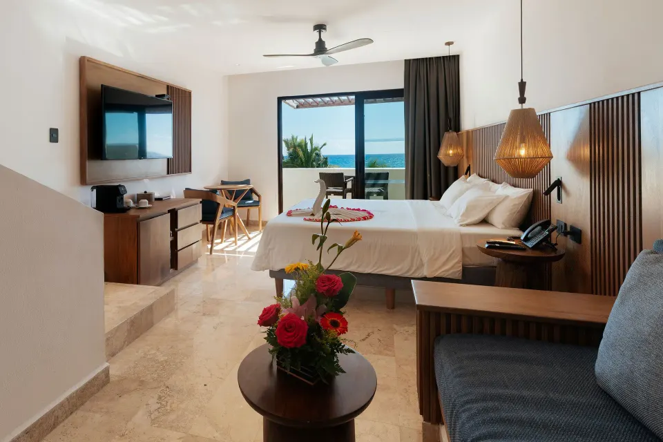 Junior Suite Penthouse king bed and seating with ocean view at Akumal Bay Beach & Wellness Resort