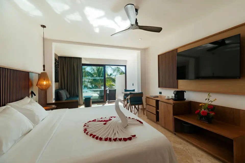 King bed and balcony in a Junior Suite Premium Ocean Front at Akumal Bay Beach & Wellness Resort