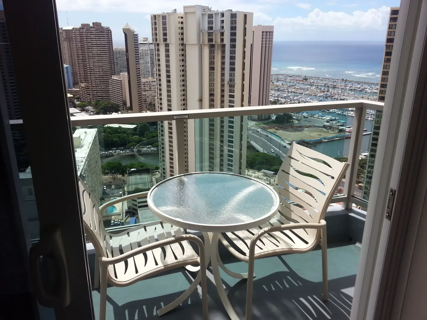 Balcony table and chairs with marina and ocean view at Ala Moana Hotel.