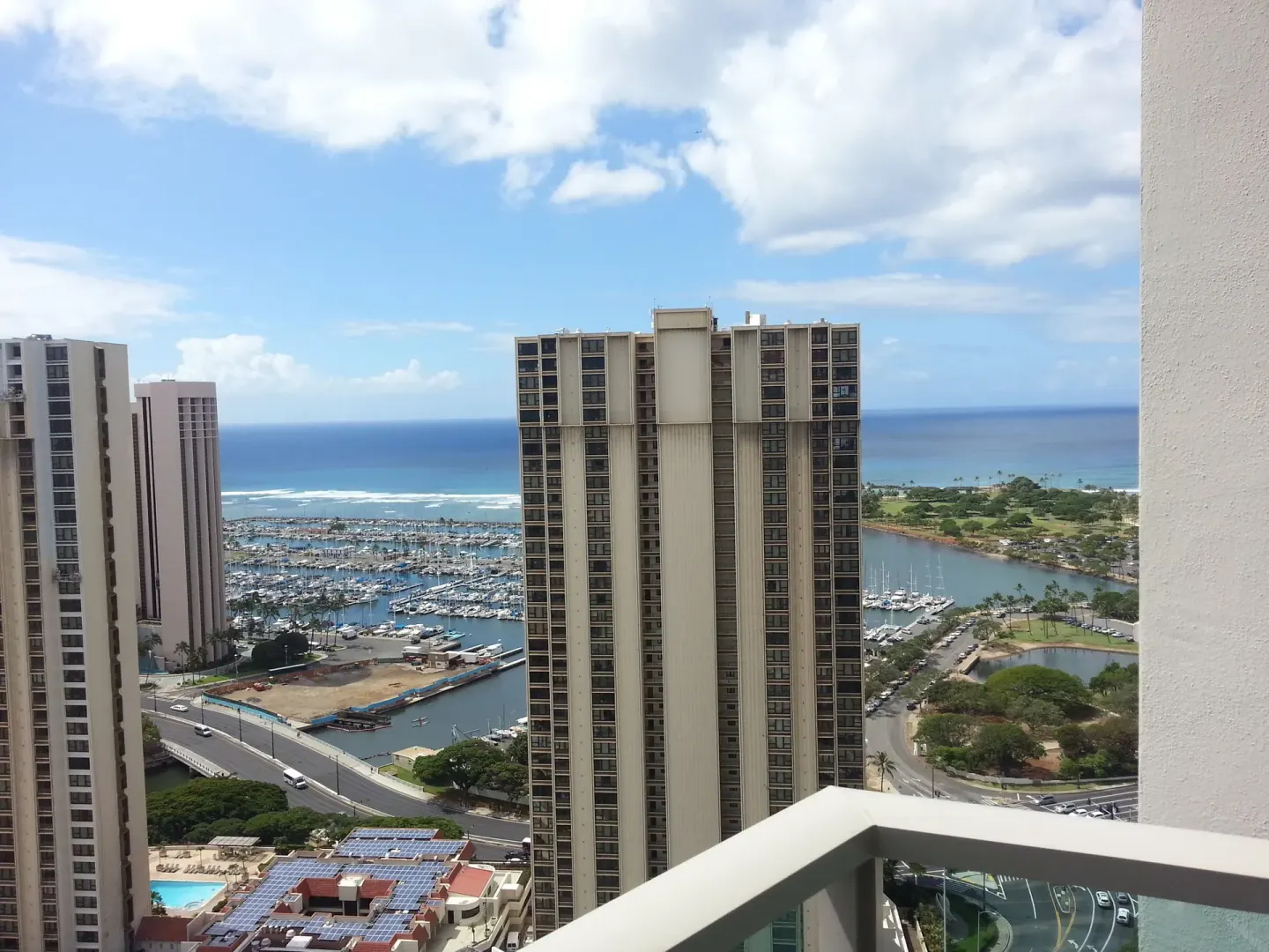 Ocean, marina, and city towers seen from a balcony at Ala Moana Hotel.