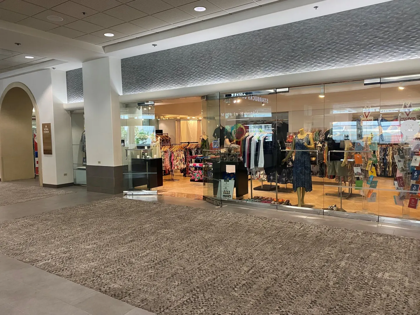 Ala Moana Hotel boutique storefront with clothing racks and mannequins behind glass.