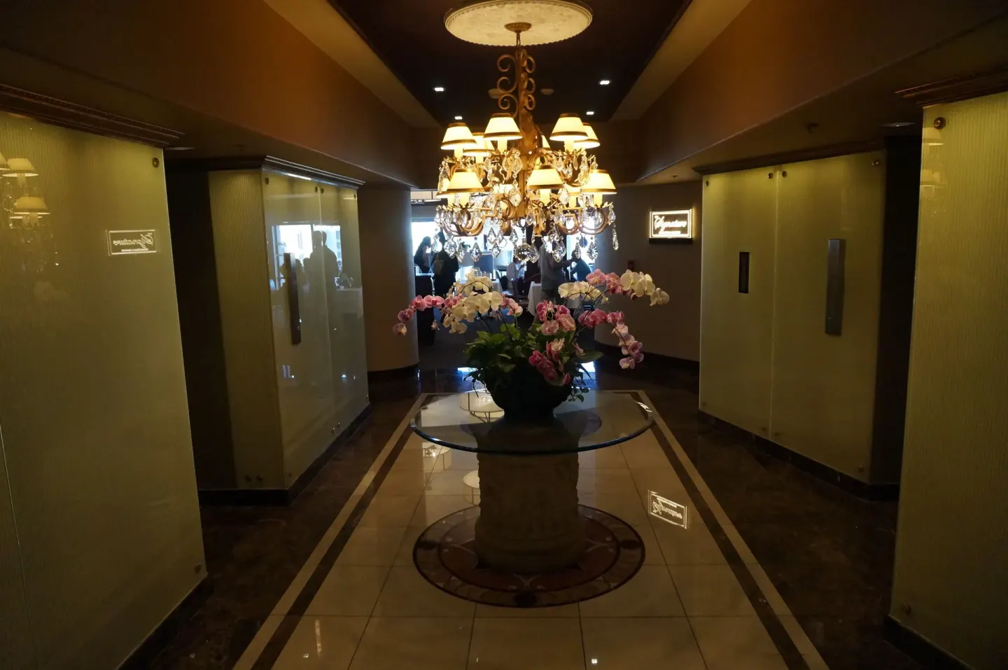 Ala Moana Hotel elevator lobby with chandelier, orchids, polished floors, and restaurant signs.