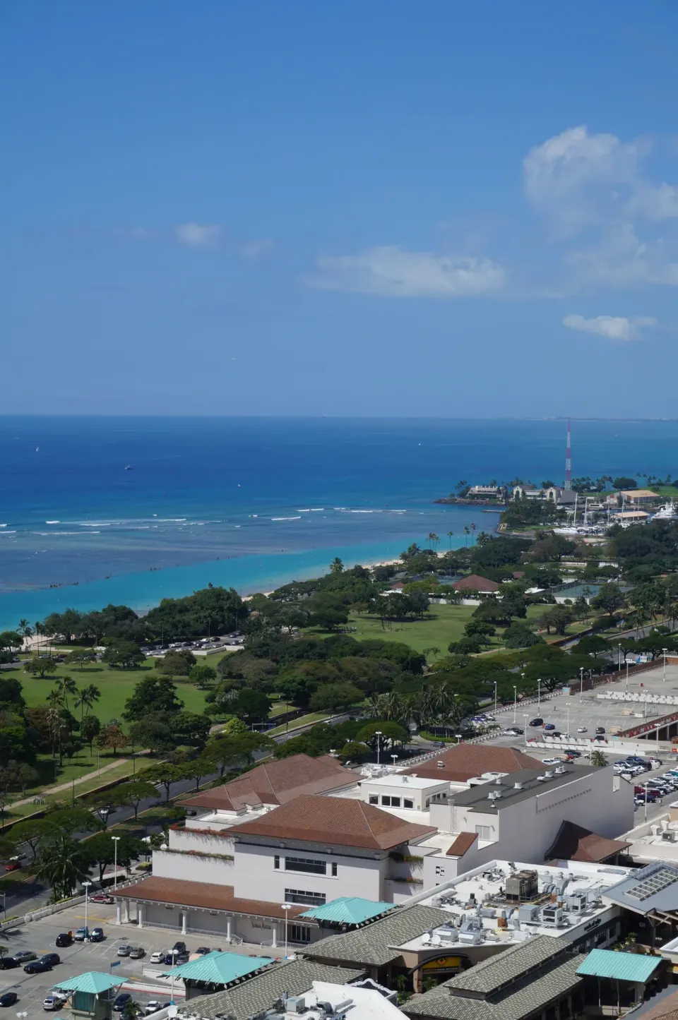 High ocean view from Ala Moana Hotel showing turquoise water, parkland, and rooftops.