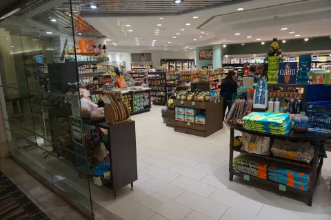 Ala Moana Hotel lobby shop with snacks, drinks, souvenirs, and folded apparel on display.
