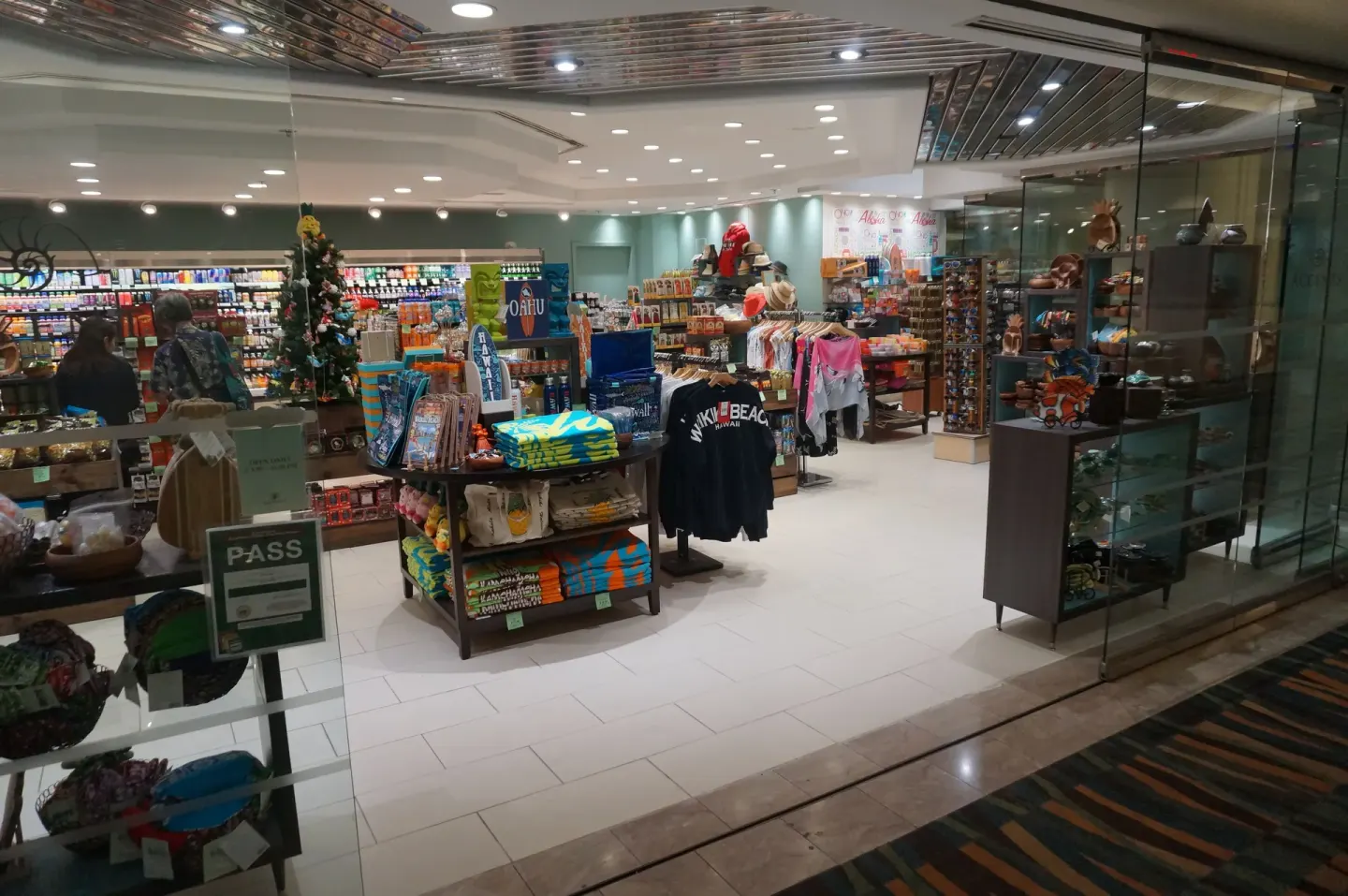 Ala Moana Hotel retail shop with souvenir clothing, snacks, and drink coolers behind glass.