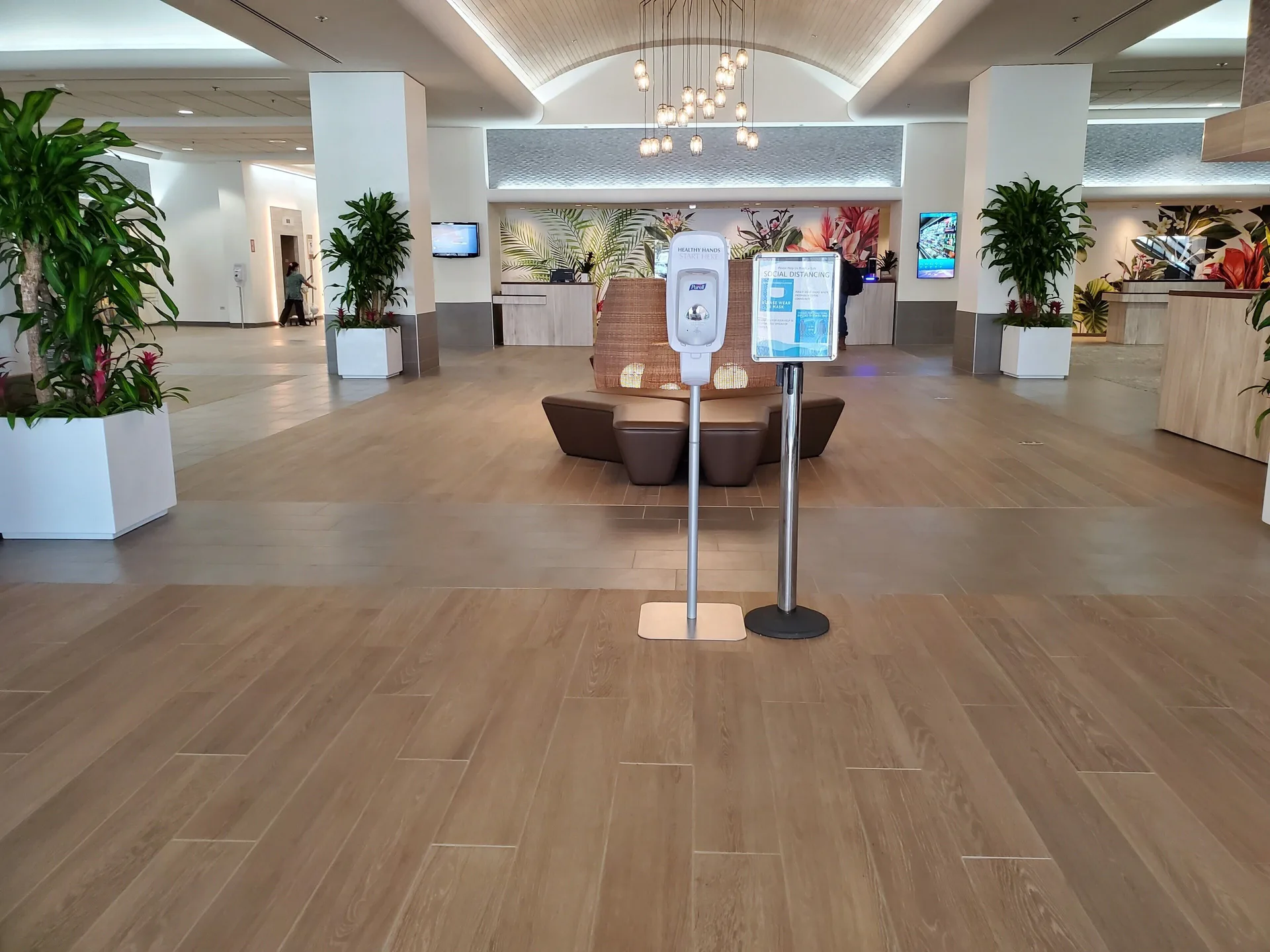 Open lobby with front desks, plants, and health signs at Ala Moana Hotel.