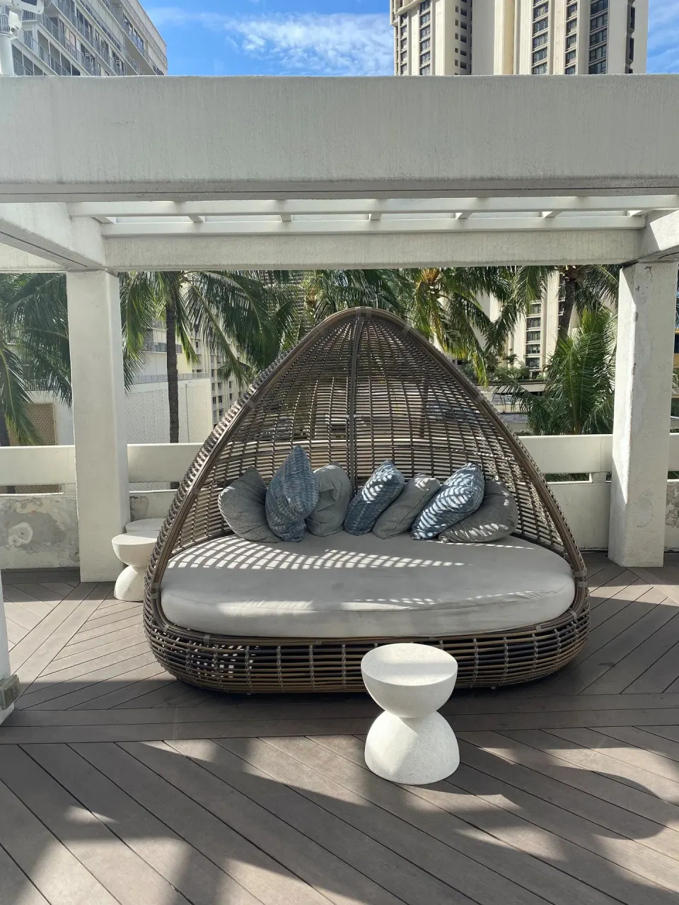 Wicker daybed with pillows on an outdoor terrace at Ala Moana Hotel.