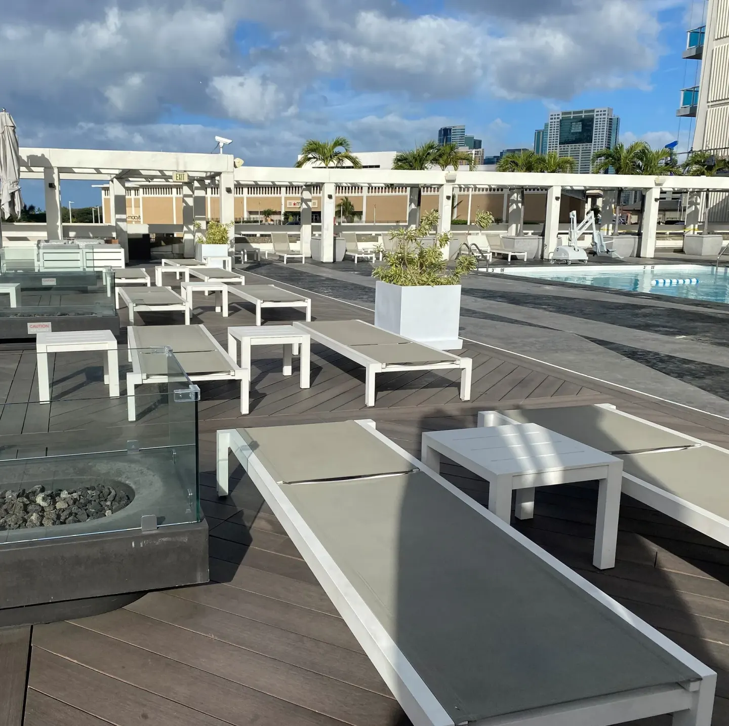 Poolside loungers, planters, and city skyline at Ala Moana Hotel.